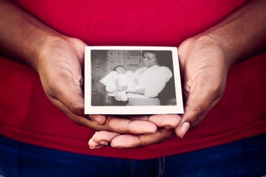 Photo of author at 3 weeks old held by their mother